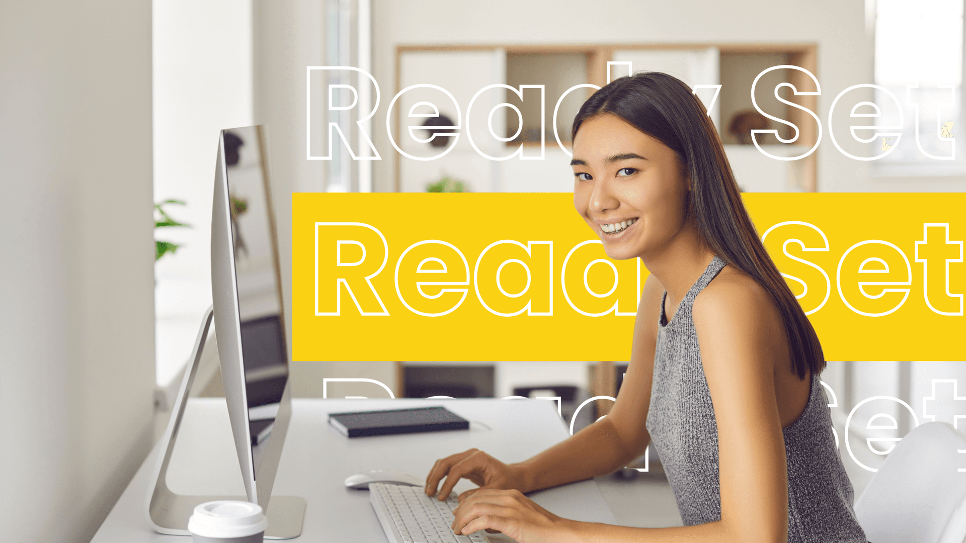 A cheerful female virtual assistant typing on a desktop computer in a bright, modern workspace. The "Ready Set" branding appears in the background, highlighting efficiency and productivity.